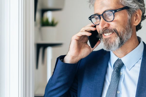 A man in a suit and tie is talking on a cell phone