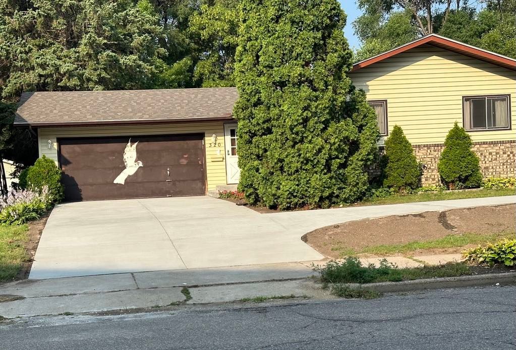 A house with a bird painted on the garage door.