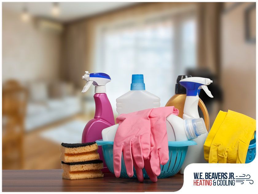 A bunch of cleaning supplies are sitting on a wooden table.