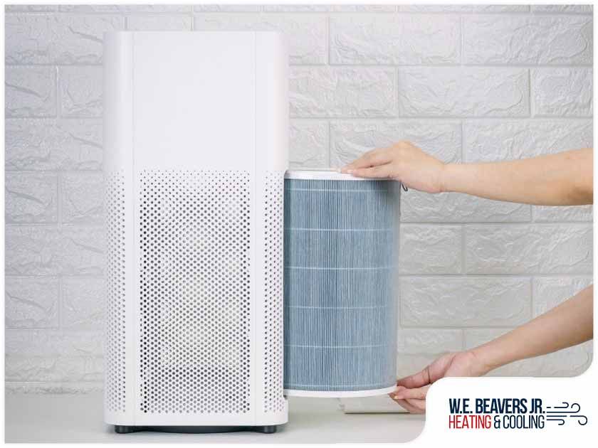 A person is changing a filter on a air purifier.