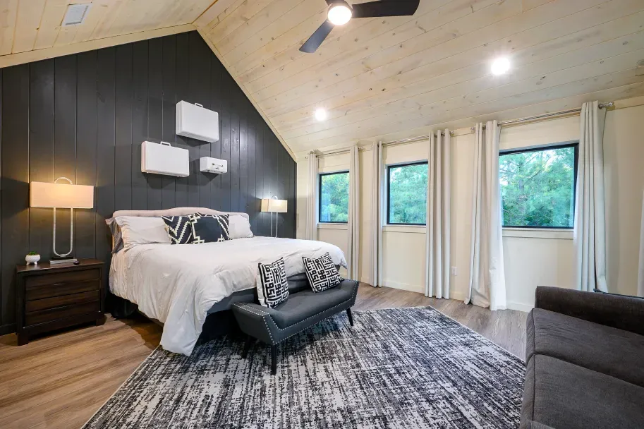 A bedroom with a king size bed and a ceiling fan.