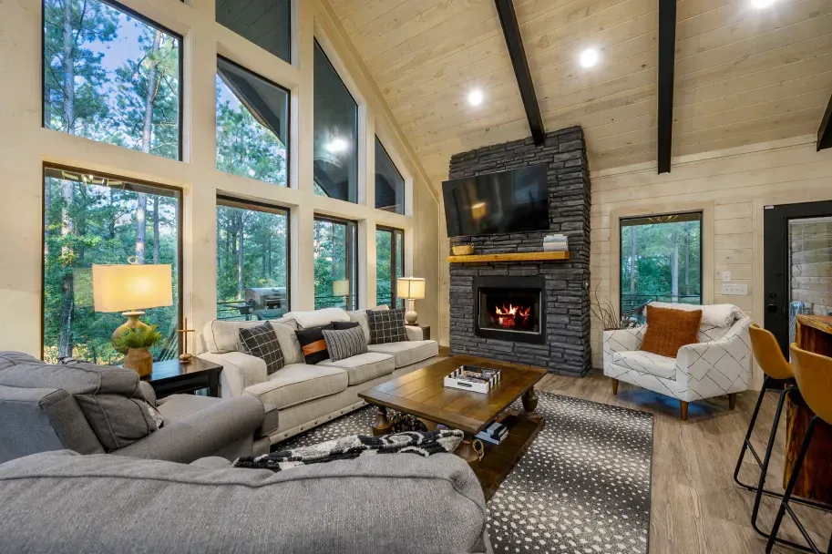 A living room with a couch , chairs , coffee table and fireplace.
