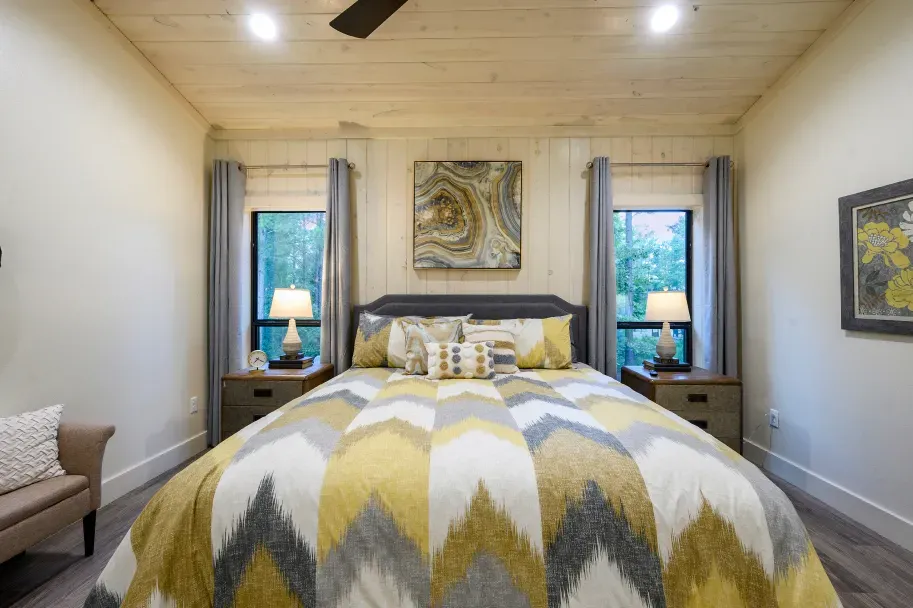 A bedroom with a king size bed and a ceiling fan.