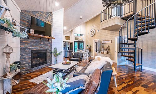 A living room with a spiral staircase and a fireplace.