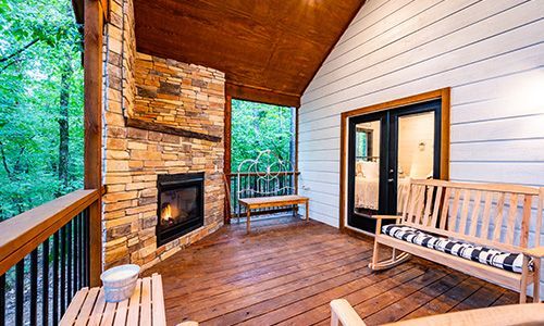 There is a fireplace on the deck of a house.