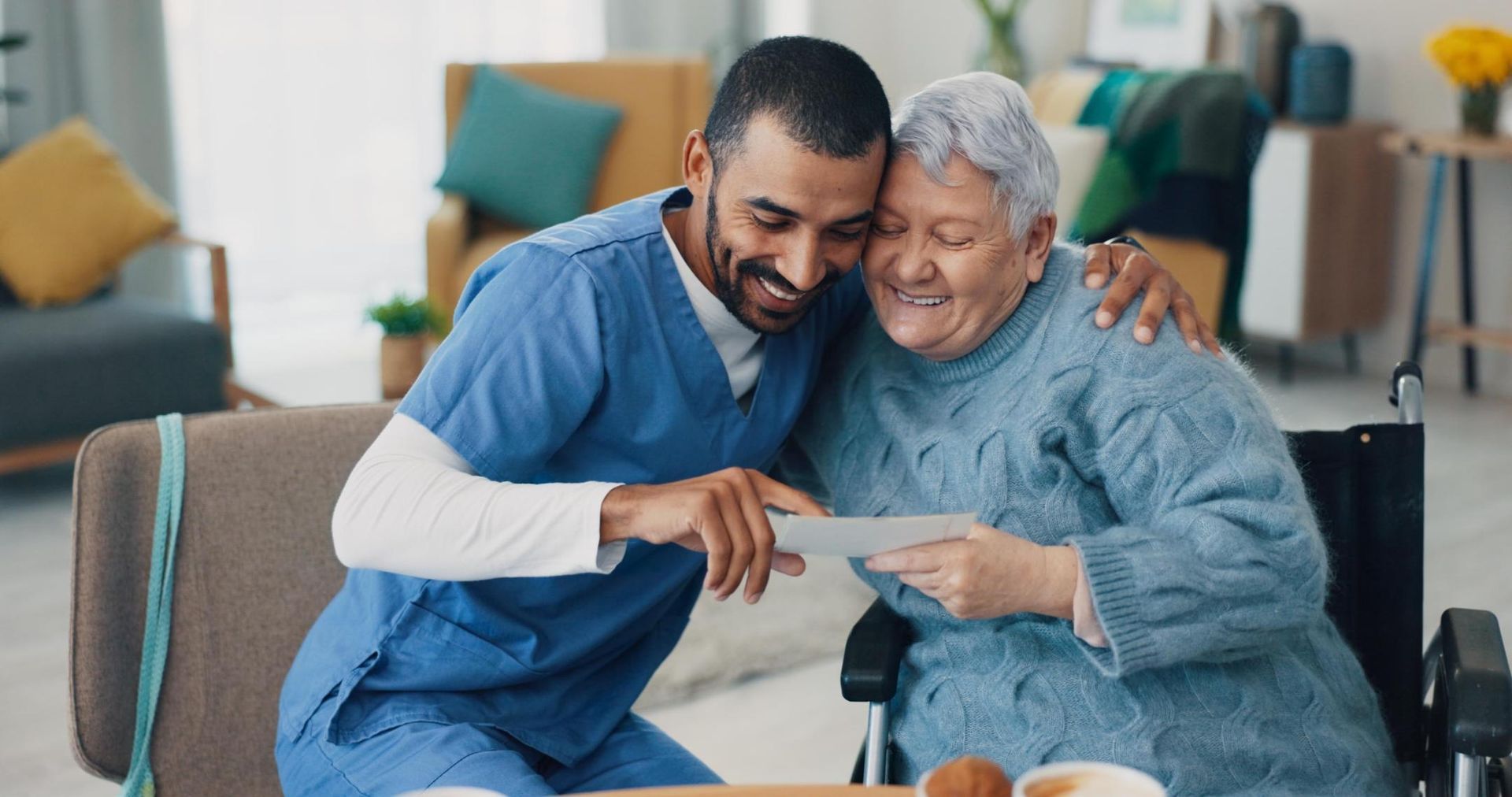 Two healthcare workers smiling and looking at a document in a bright lounge