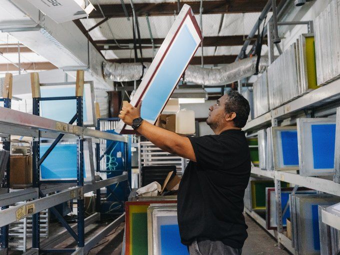 Screen print screens racked on the production floor at Hightech Grafix