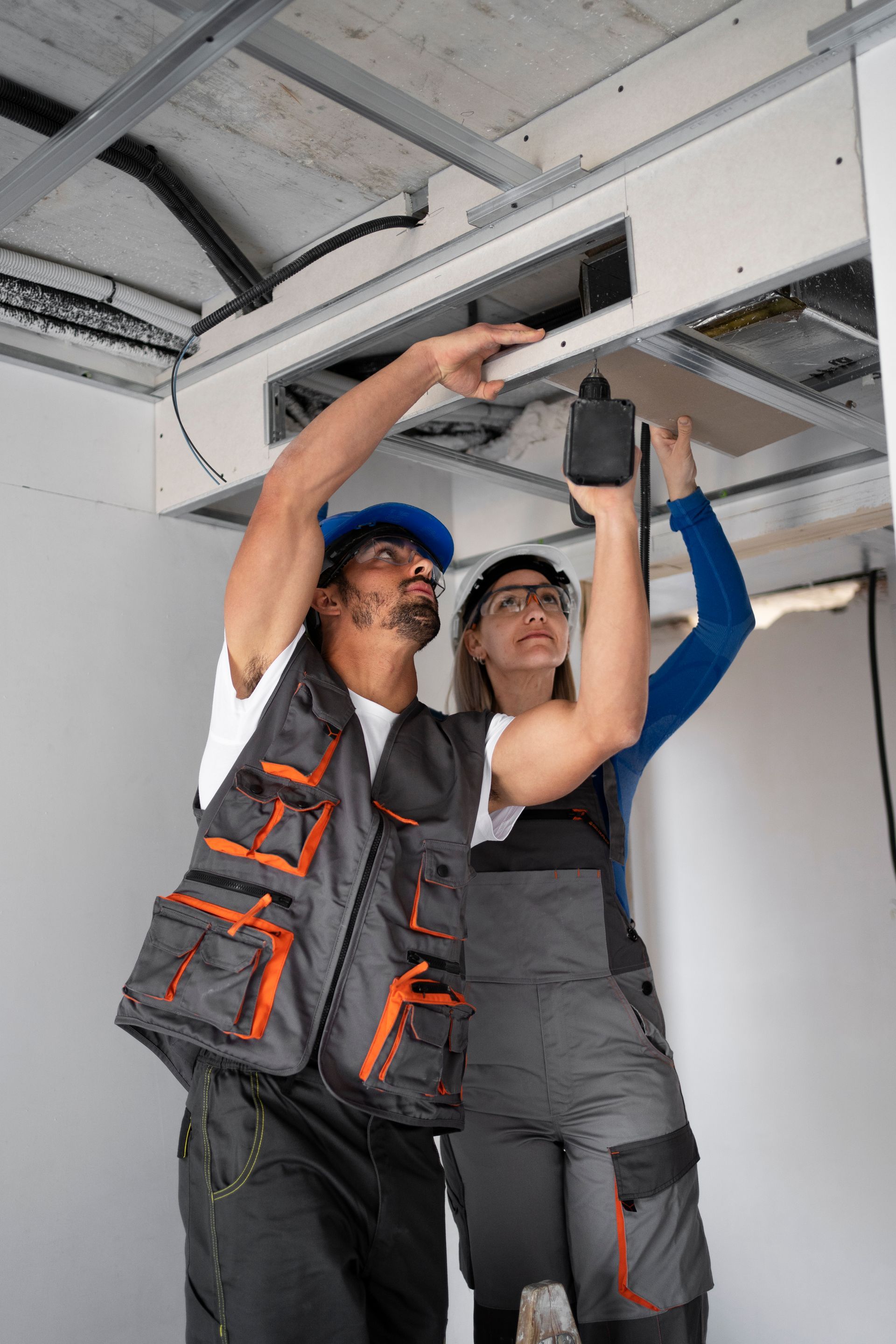 Un hombre y una mujer están trabajando en un techo.