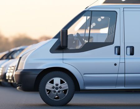 Silver van parked beside other vehicles at dusk