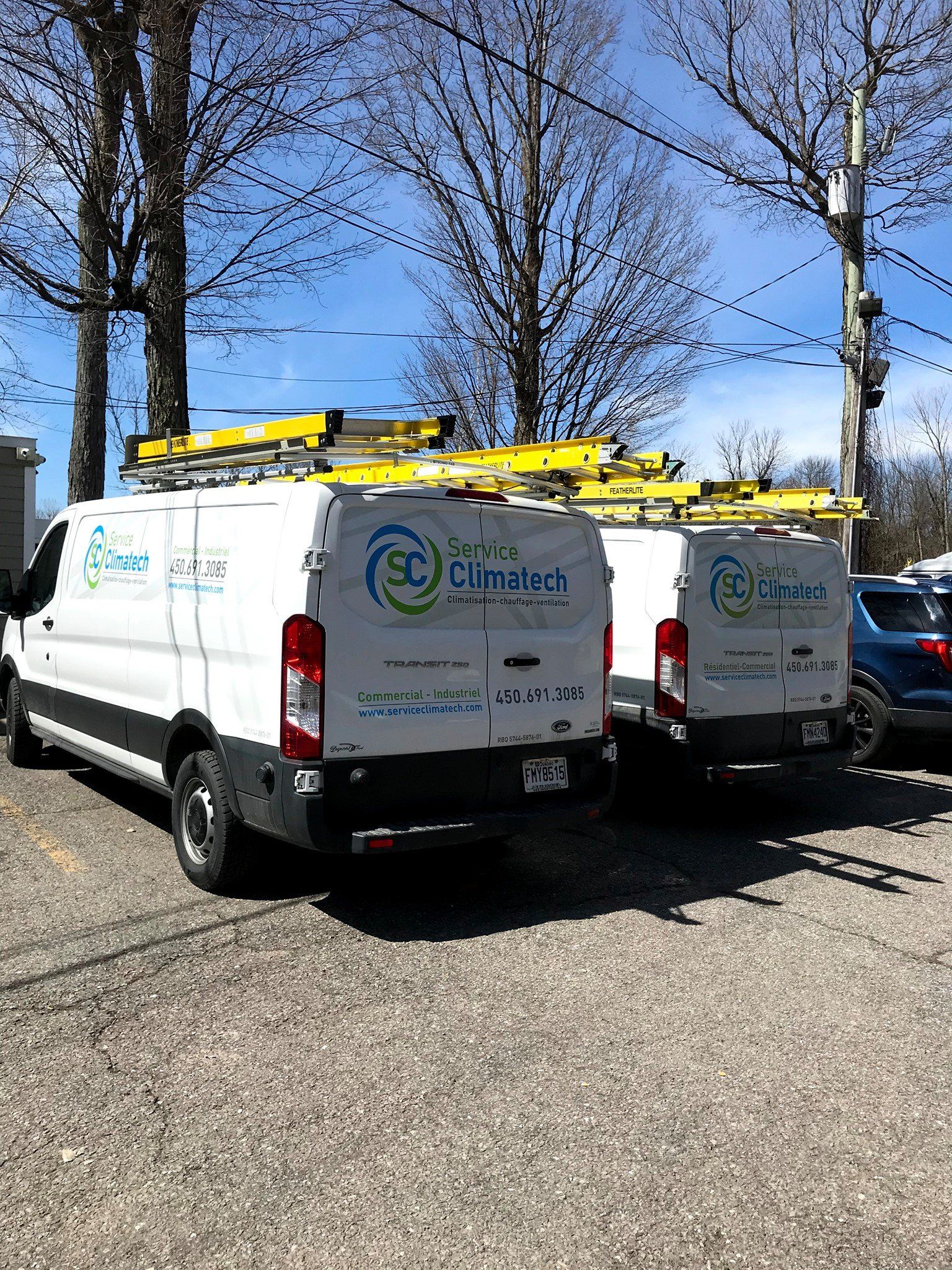 Deux camionnettes blanches sont garées l’une à côté de l’autre dans un parking.