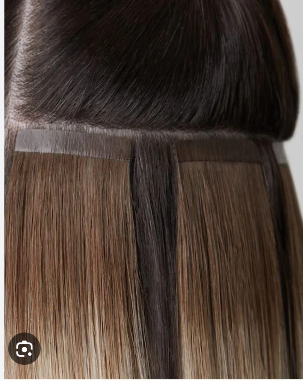 Extension per capelli castano scuro con fascia superiore dritta, che lasciano intravedere ciocche castano chiaro al di sotto.