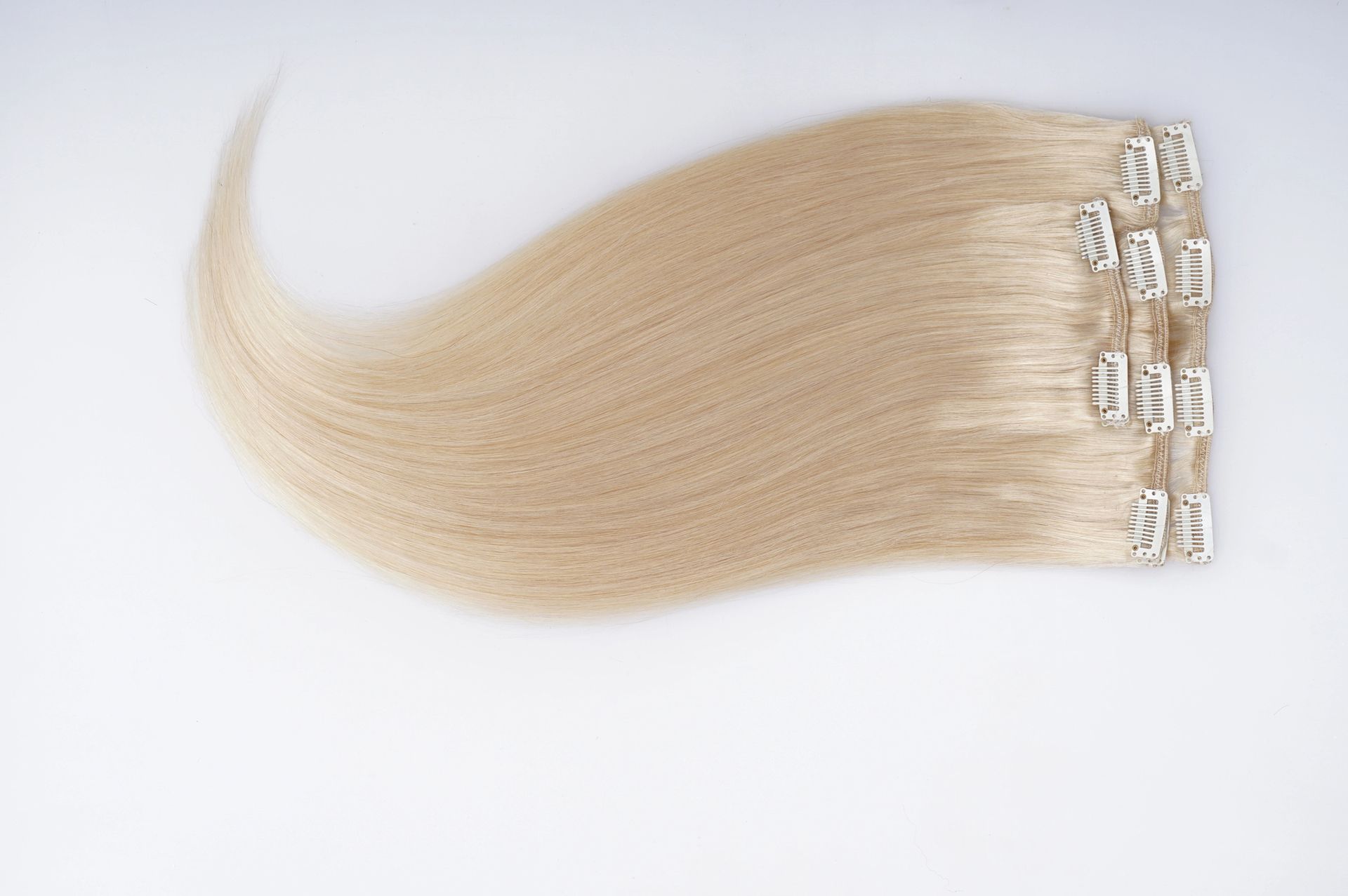 Extension per capelli biondi con ciocche ondulate su sfondo bianco.