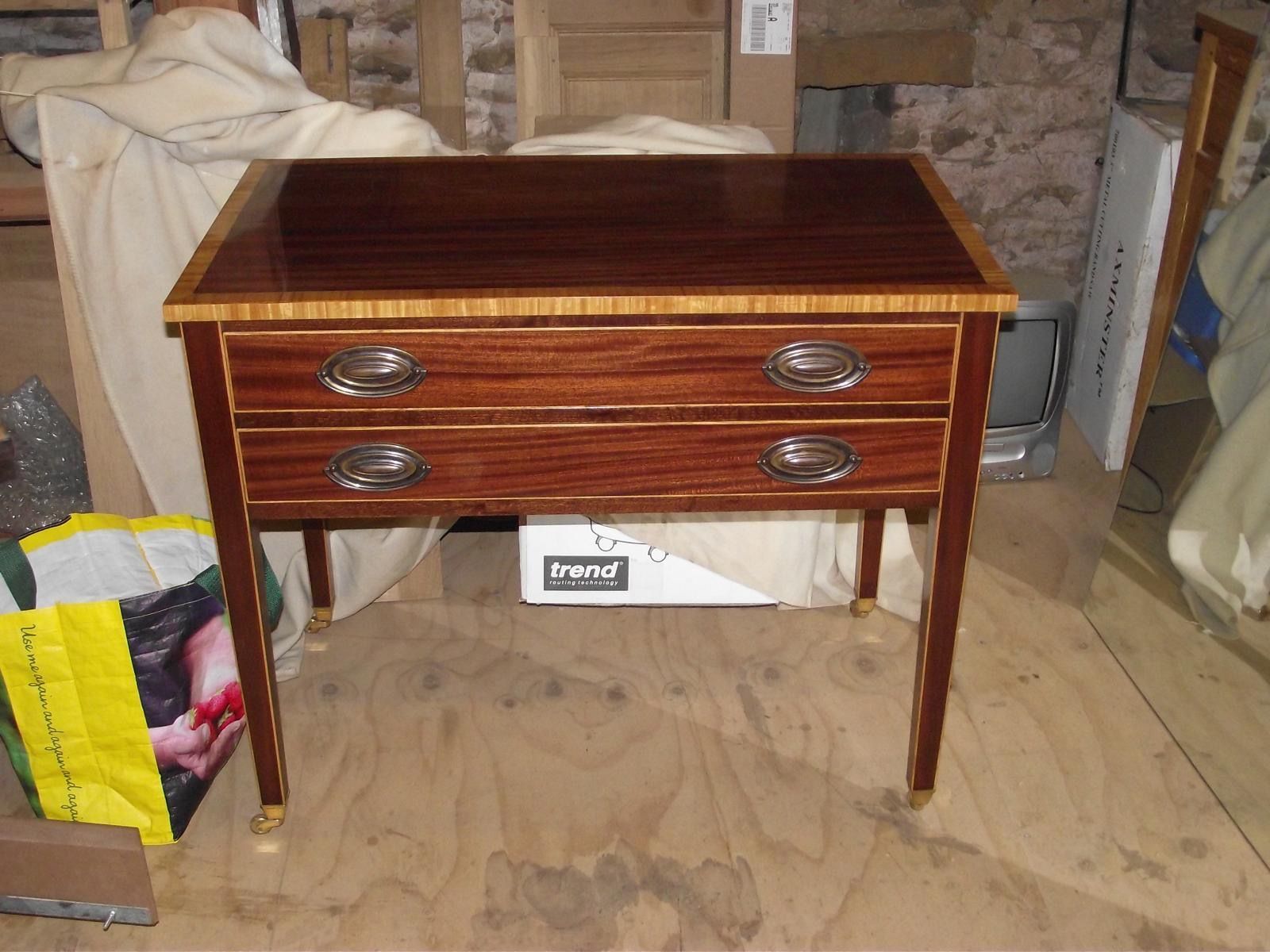 A wooden table with two drawers and a box that says ' french ' on it