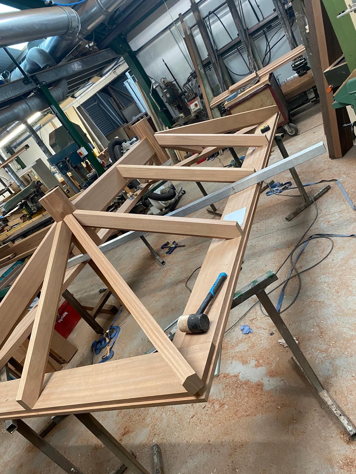 A wooden structure is being built in a workshop.