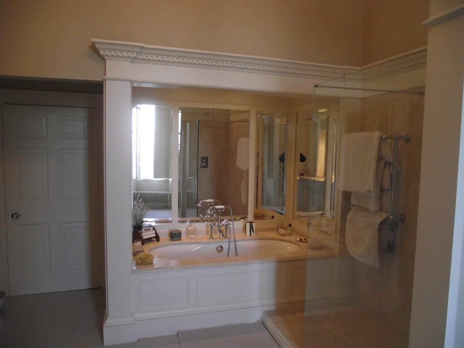 A bathroom with a bathtub and a large mirror