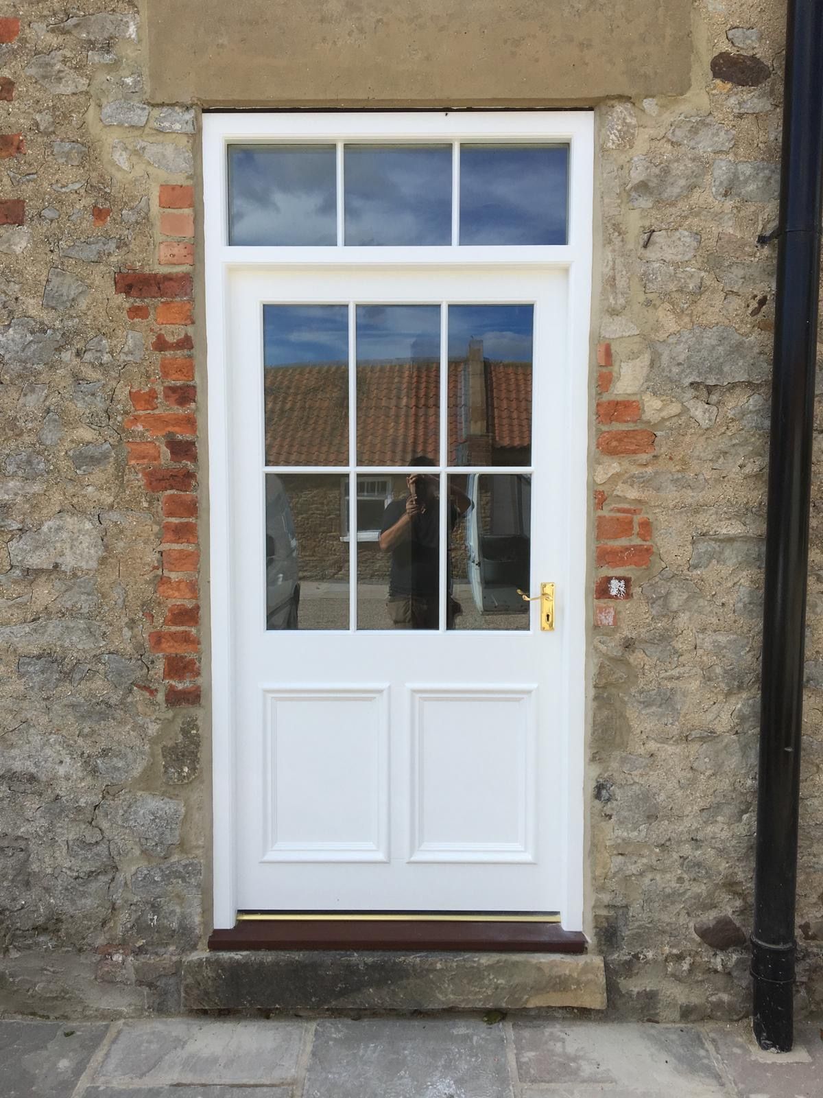 A white door with a brick wall behind it