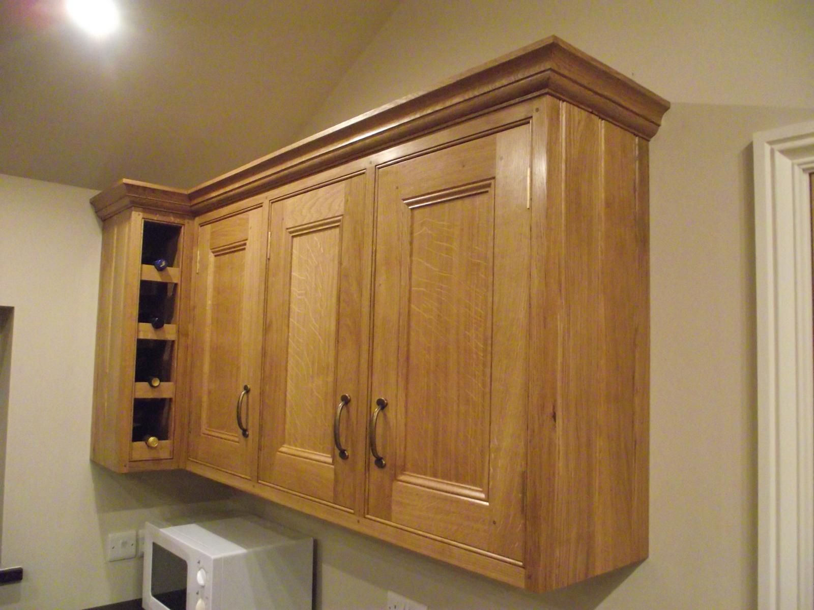 A kitchen with wooden cabinets and a microwave.