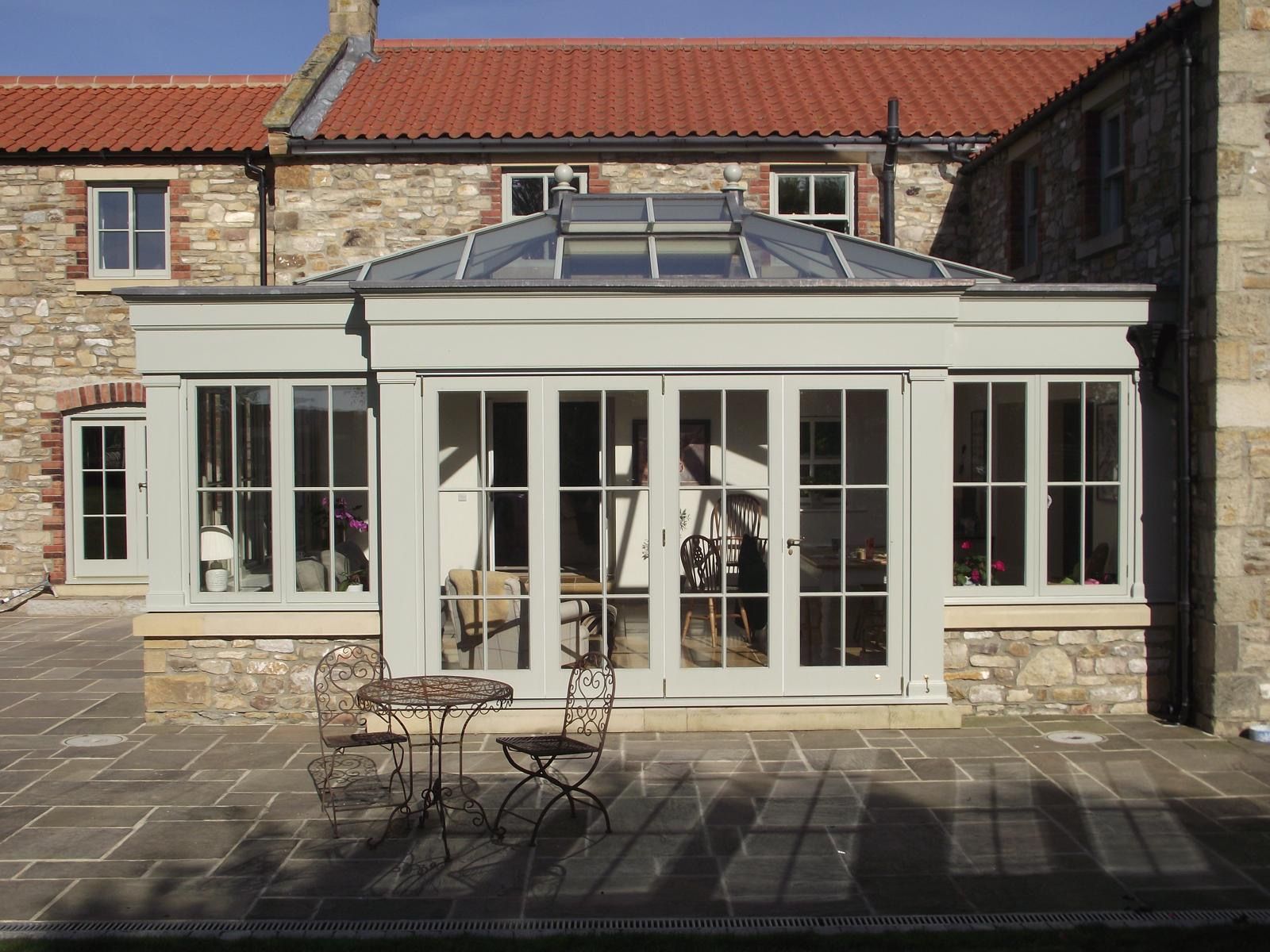 A large house with a patio and a table and chairs in front of it