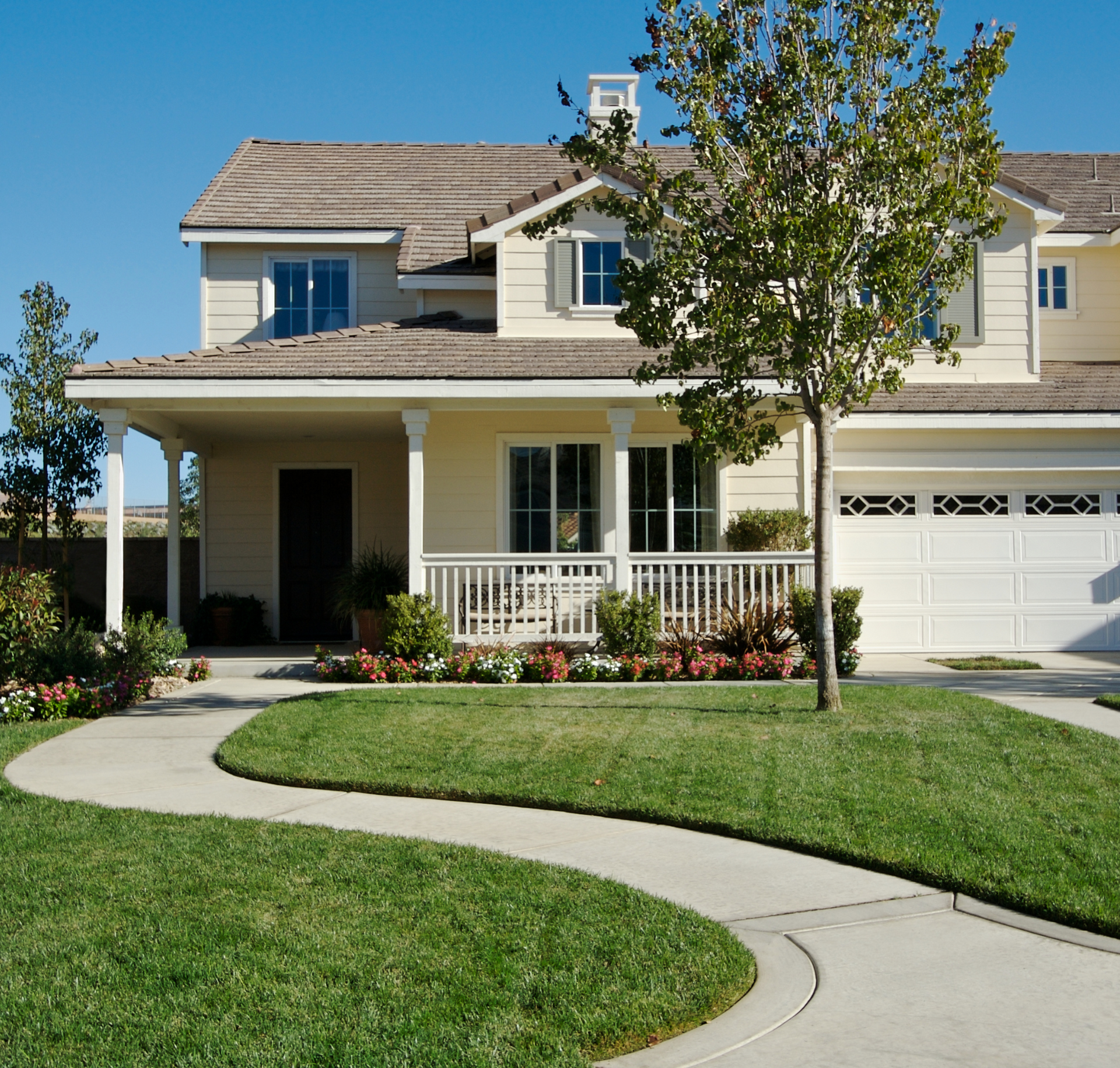 A large white house with a concrete walkway leading to it