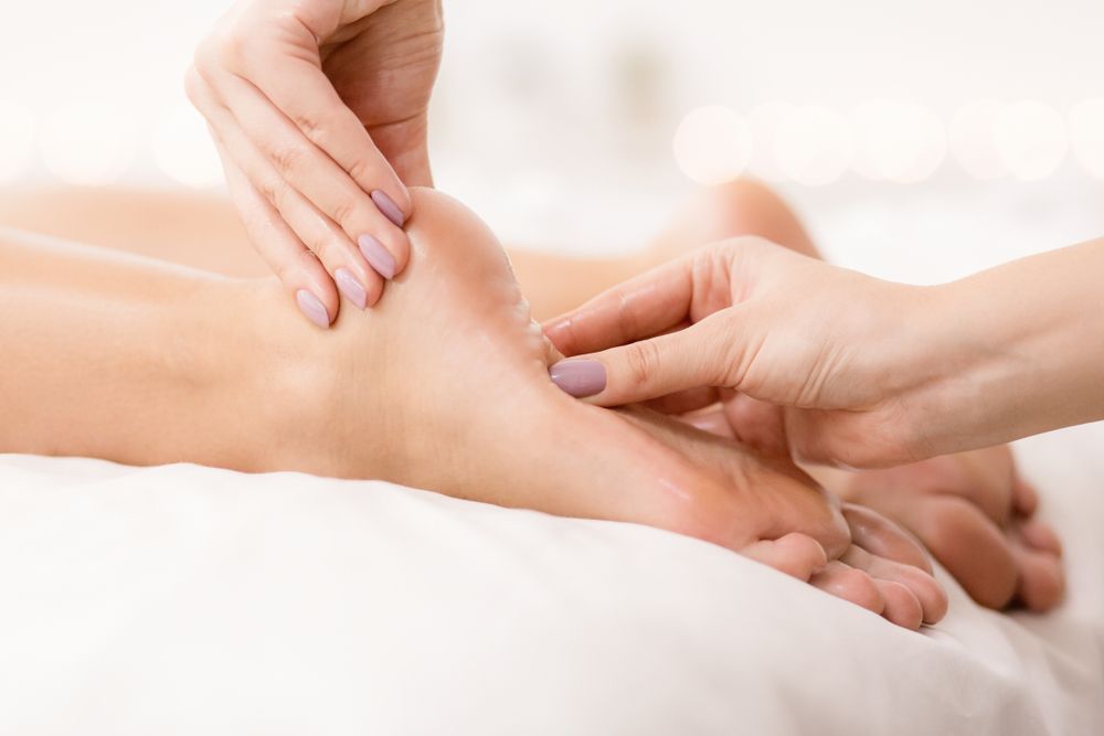 A Woman is Getting a Foot Massage at a Spa — Newcastle Foot & Ankle Clinic Charlestown In Belmont, NSW