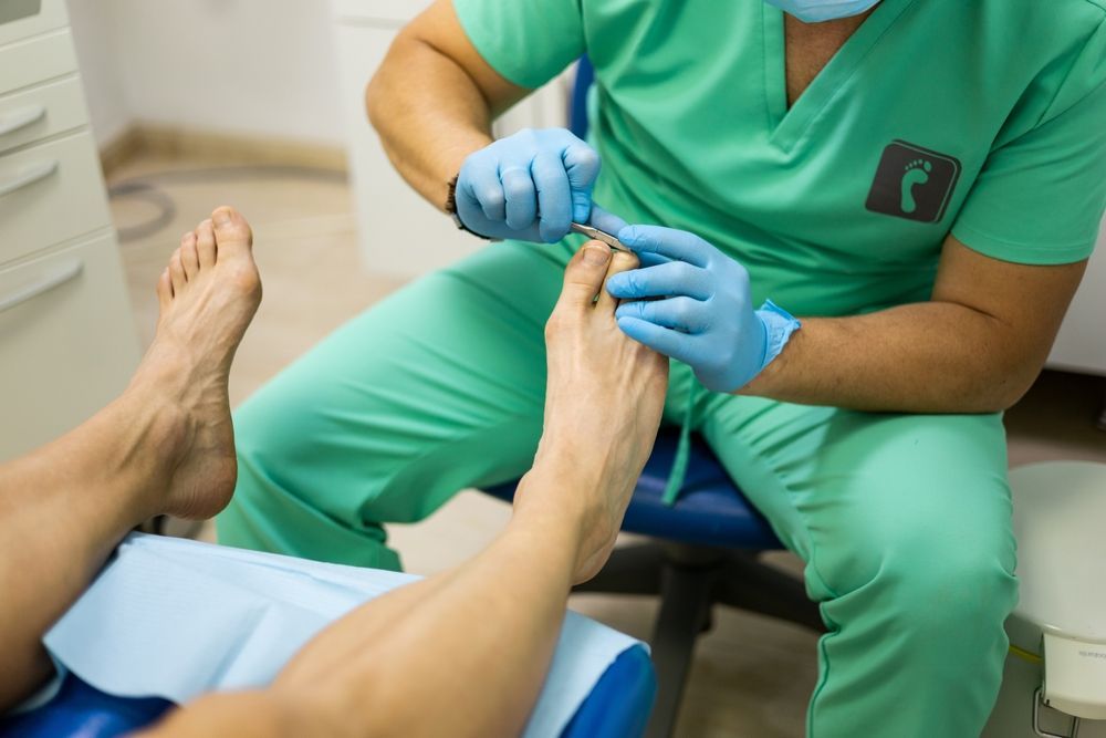 A Man is Getting His Feet Examined by a Doctor — Newcastle Foot & Ankle Clinic Charlestown In Charlestown, NSW