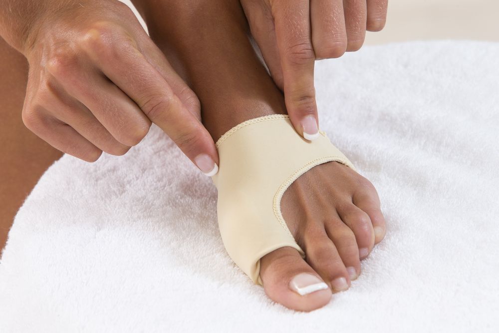 A Person is Putting a Bandage on Their Foot — Newcastle Foot & Ankle Clinic Charlestown In Maitland, NSW