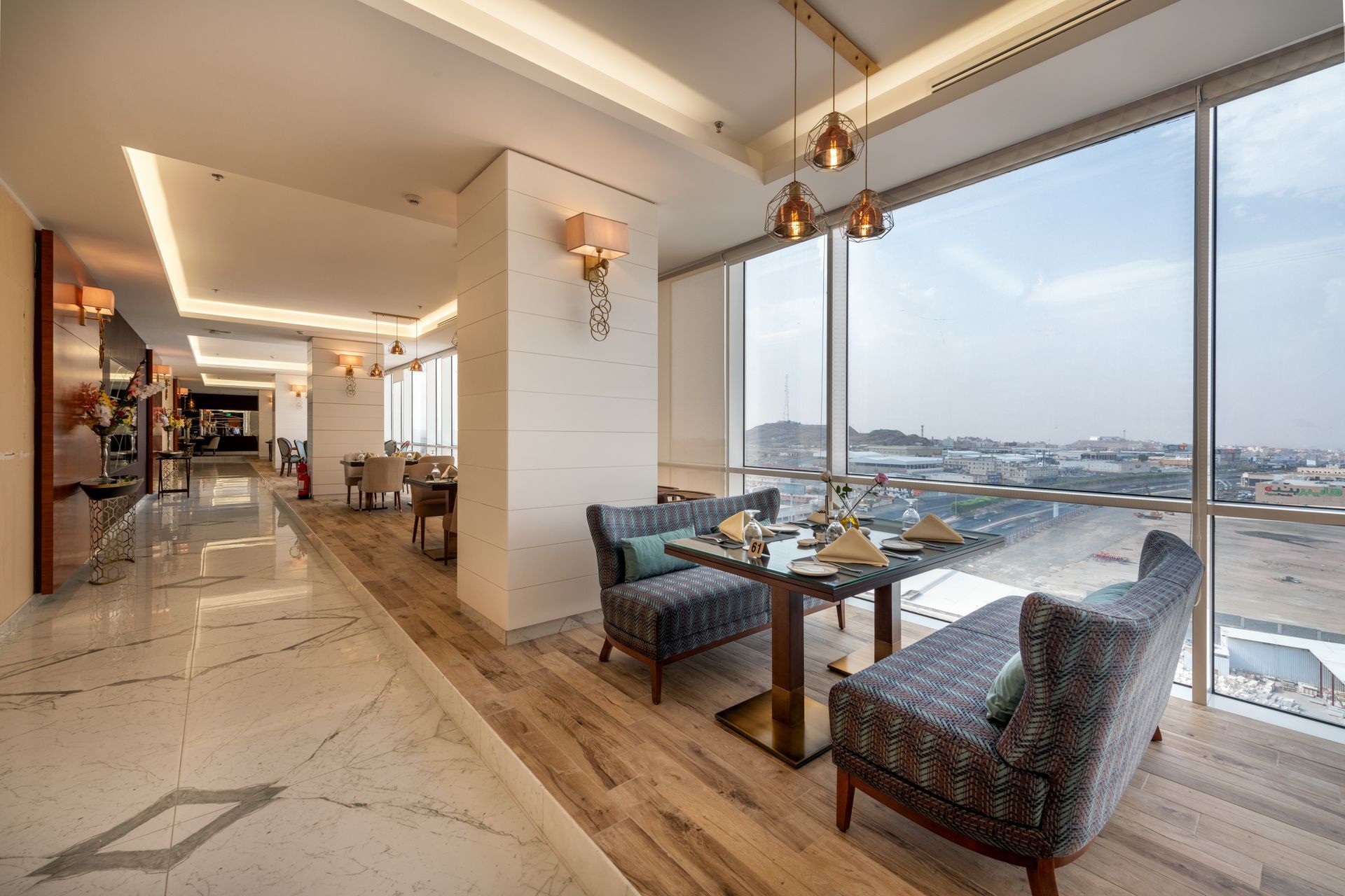 Modern dining area with large windows overlooking a snowy waterfront cityscape