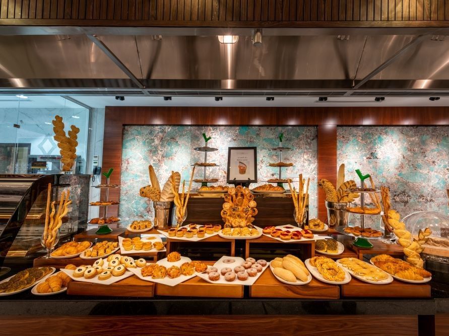 Buffet table with assorted pastries and breads in a modern restaurant setting