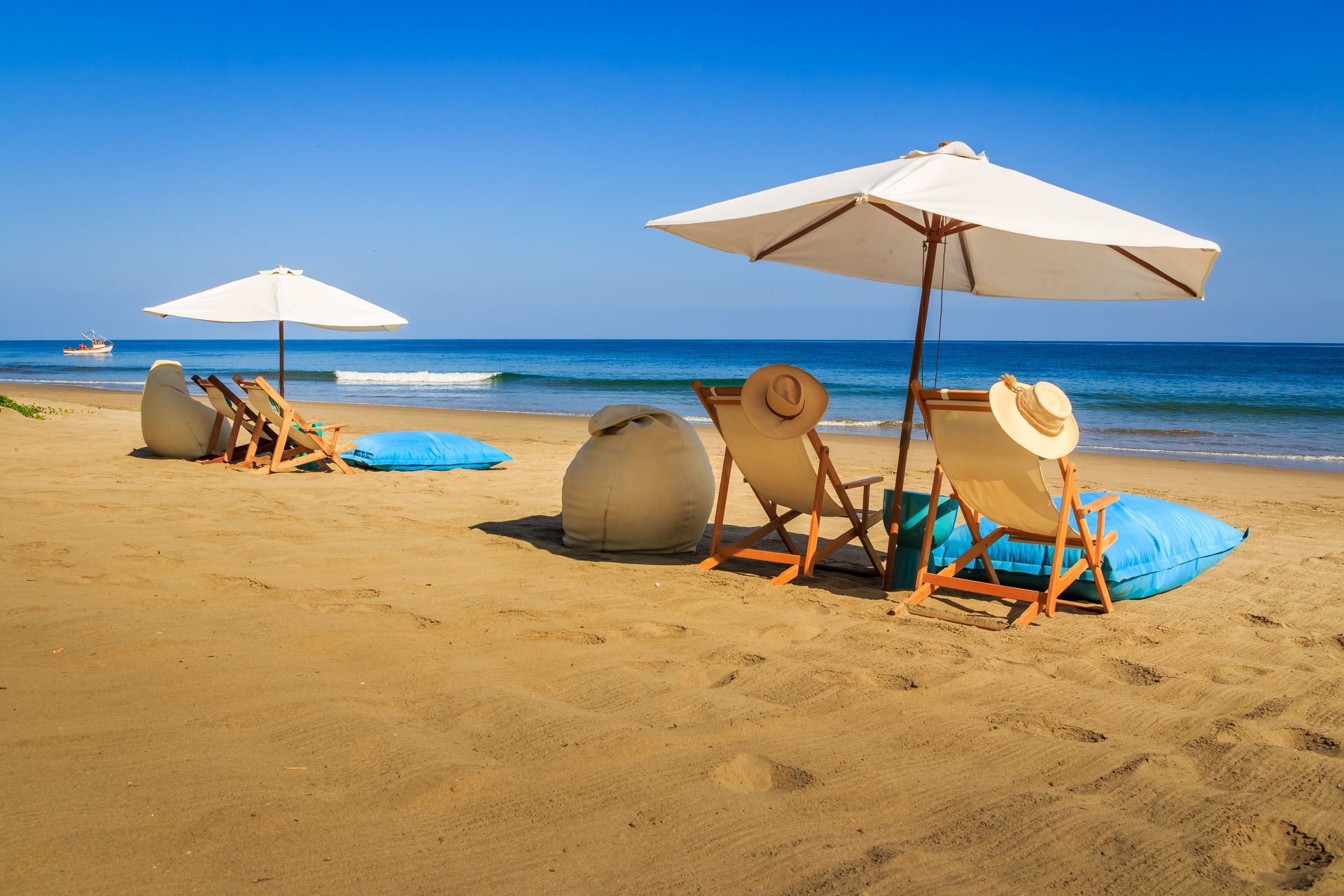 There are umbrellas and chairs on the beach.