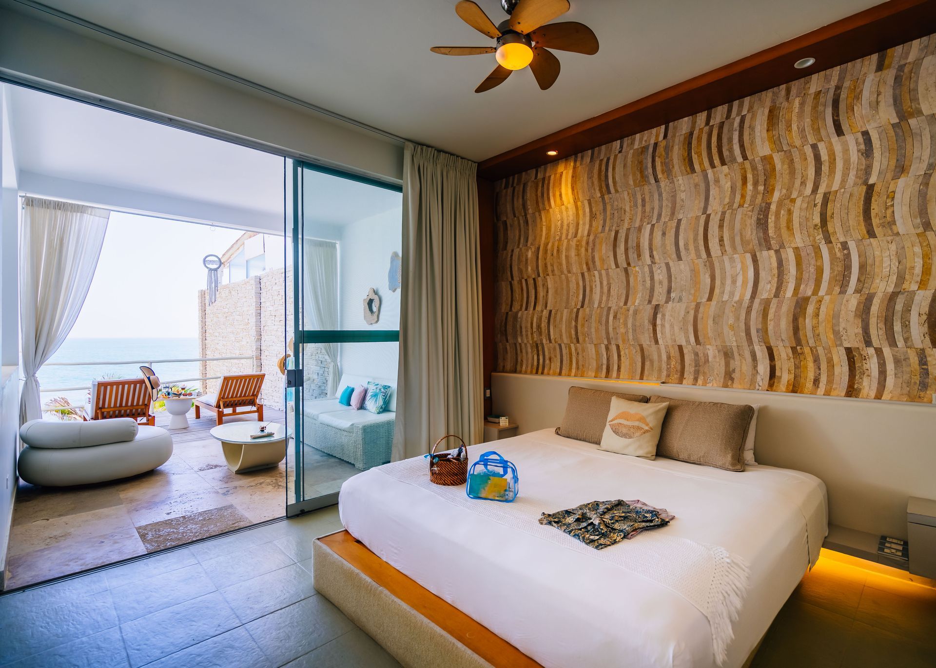 A hotel room with a king size bed and a ceiling fan.