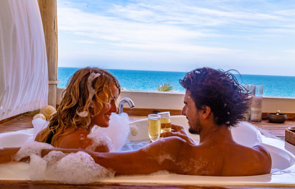 A man and a woman are taking a bath in a jacuzzi.