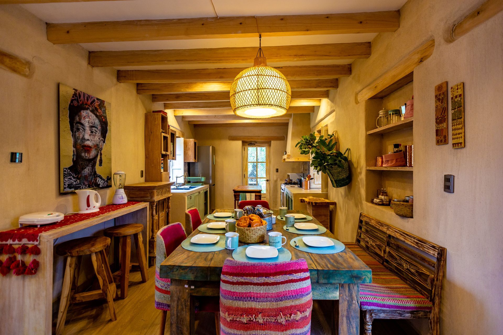A dining room with a long wooden table and chairs.