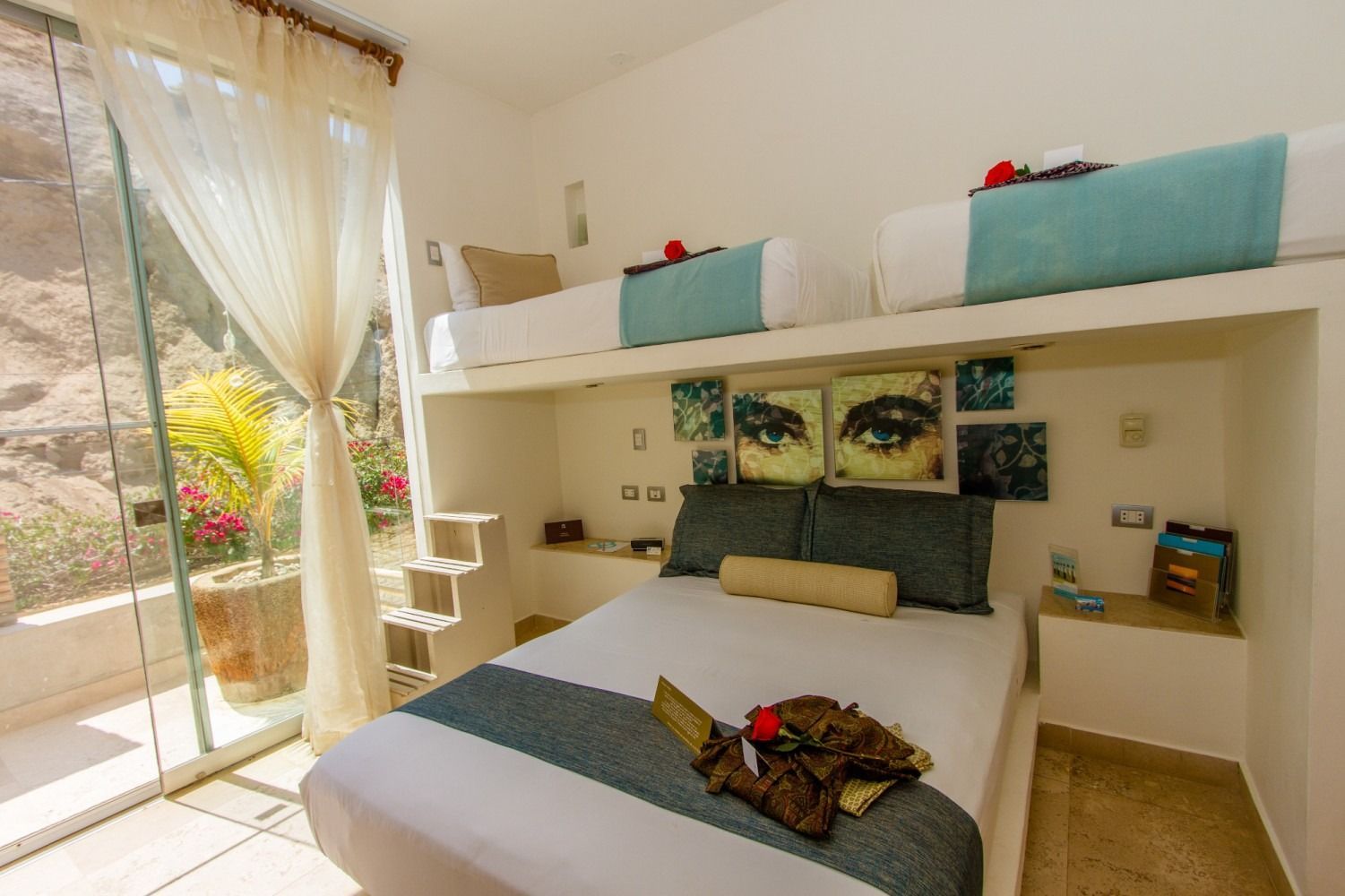 A bedroom with a bed and two bunk beds.