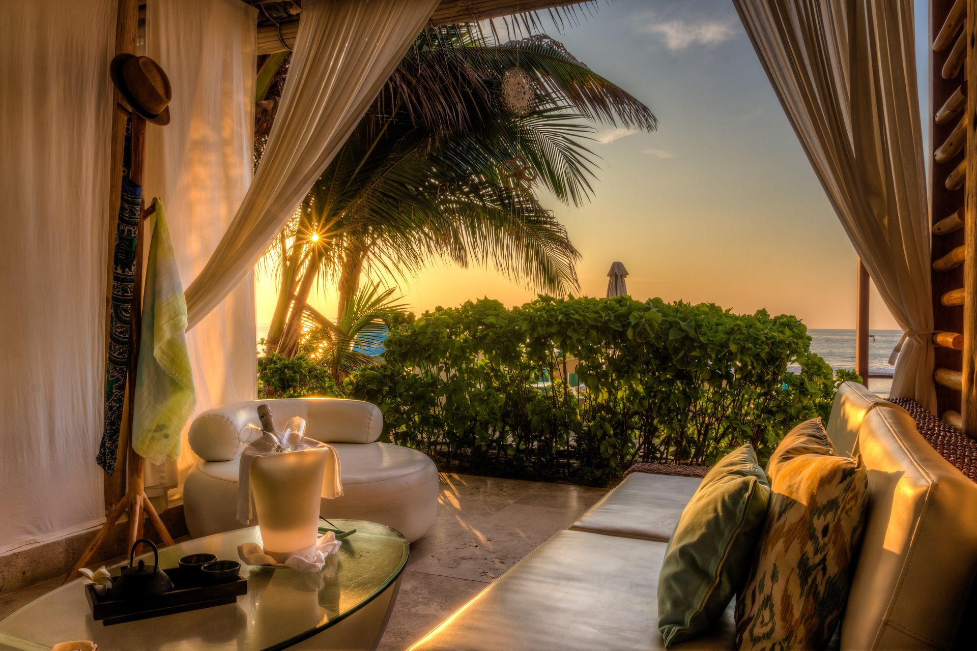 A cabana with a view of the ocean at sunset