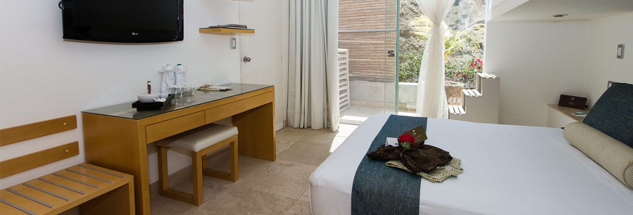 A hotel room with a bed , desk and television.