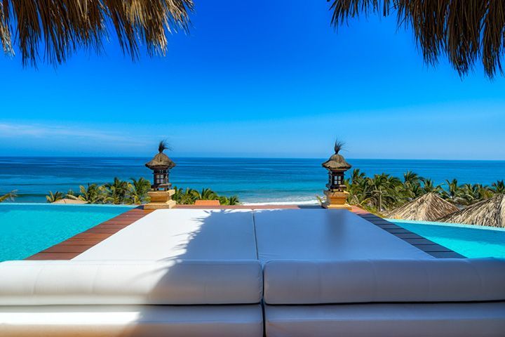 There is a swimming pool with a view of the ocean.