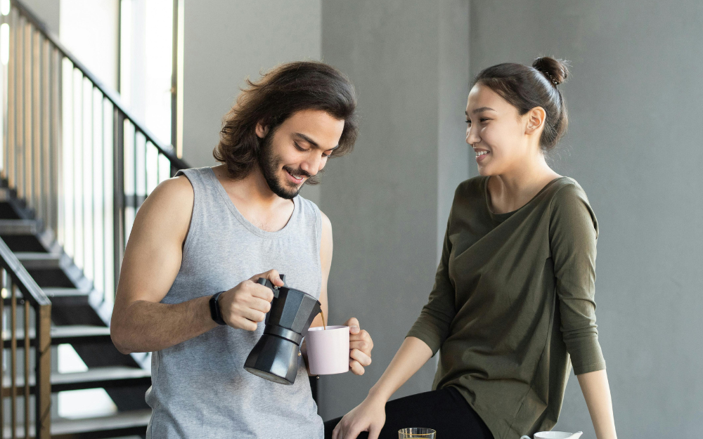 Man Pouring Coffee for Woman Indoors — Midcoast Financial Planning Group in Tuncurry, NSW
