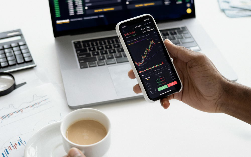 Person holding phone displaying stock — Midcoast Financial Planning Group in Tuncurry, NSW