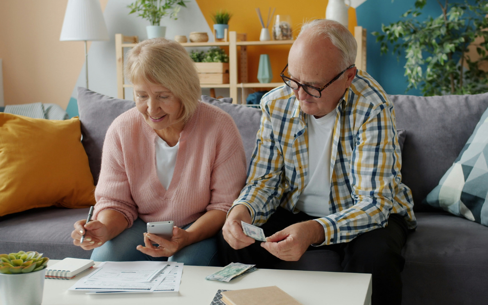 Older Couple on Couch Reviewing Finances — Midcoast Financial Planning Group in Tuncurry, NSW