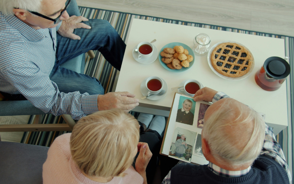 Three People Looking at Photos — Midcoast Financial Planning Group in Tuncurry, NSW