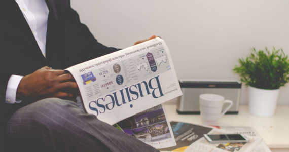 Person in Suit Reading a Business Newspaper — Midcoast Financial Planning Group in Tuncurry, NSW
