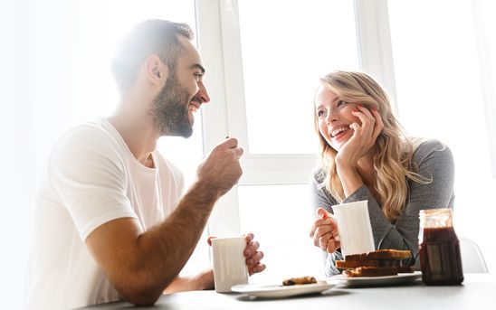 A Smiling Couple at A Table — Midcoast Financial Planning Group in Tuncurry, NSW
