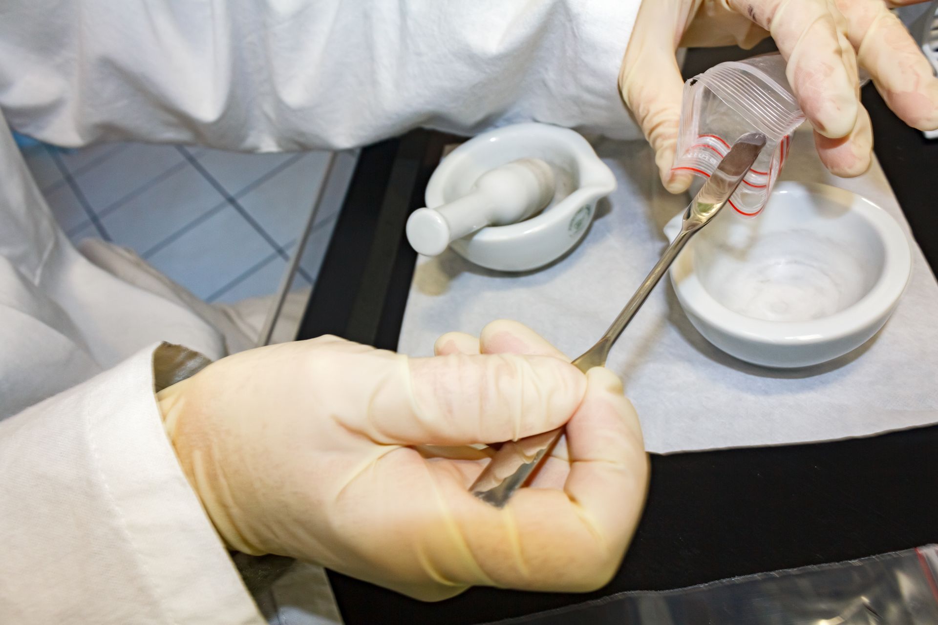 scooping asbestos from small plastic to test
