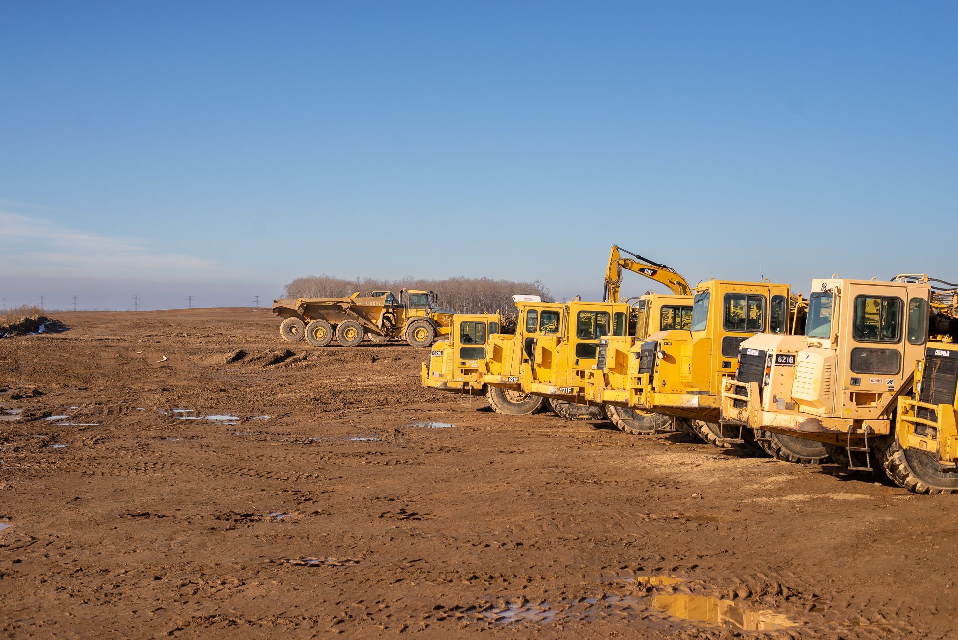 Row of yellow construction vehicles photography by Lume Creative