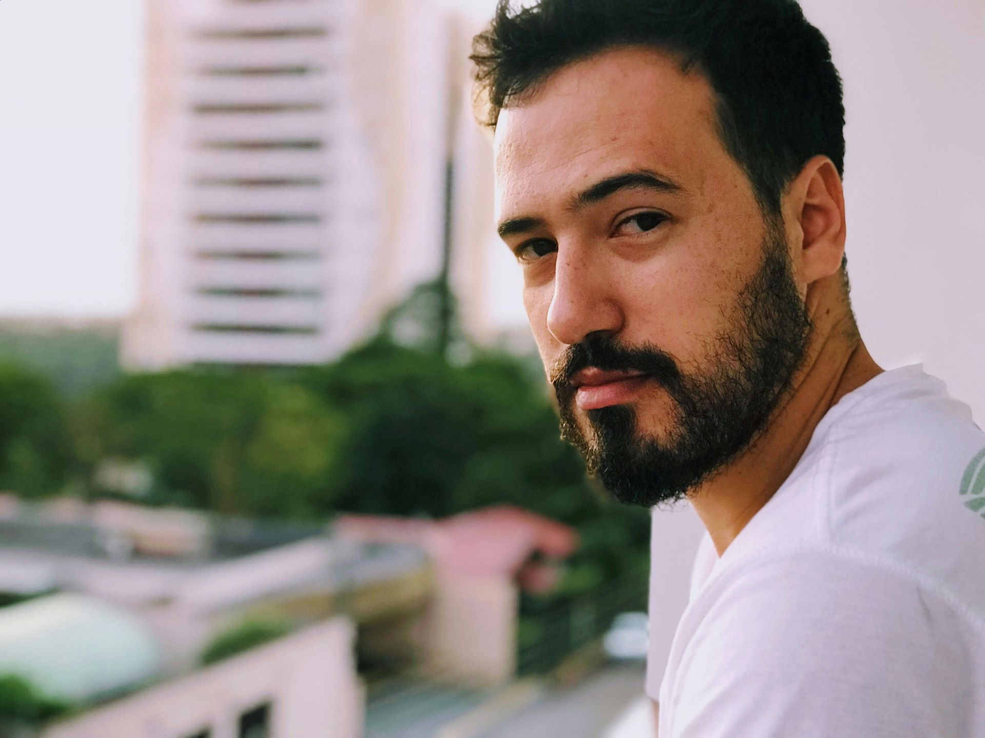 A man with a beard is wearing a white shirt