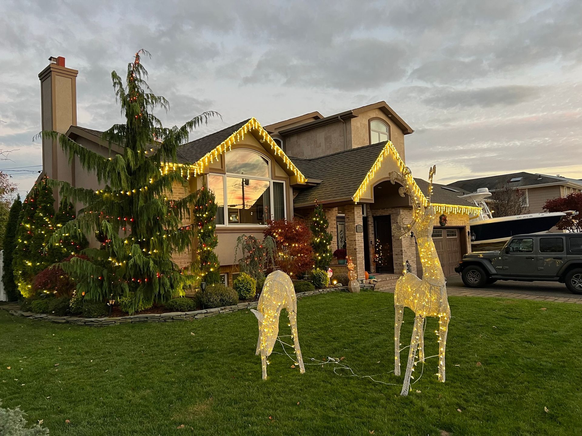 Silvers, Inc. - House decorated with Christmas lights and reindeer yard ornaments on a lawn.