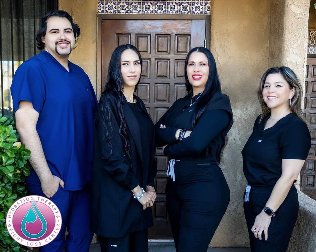 A group of people are posing for a picture in front of a door.