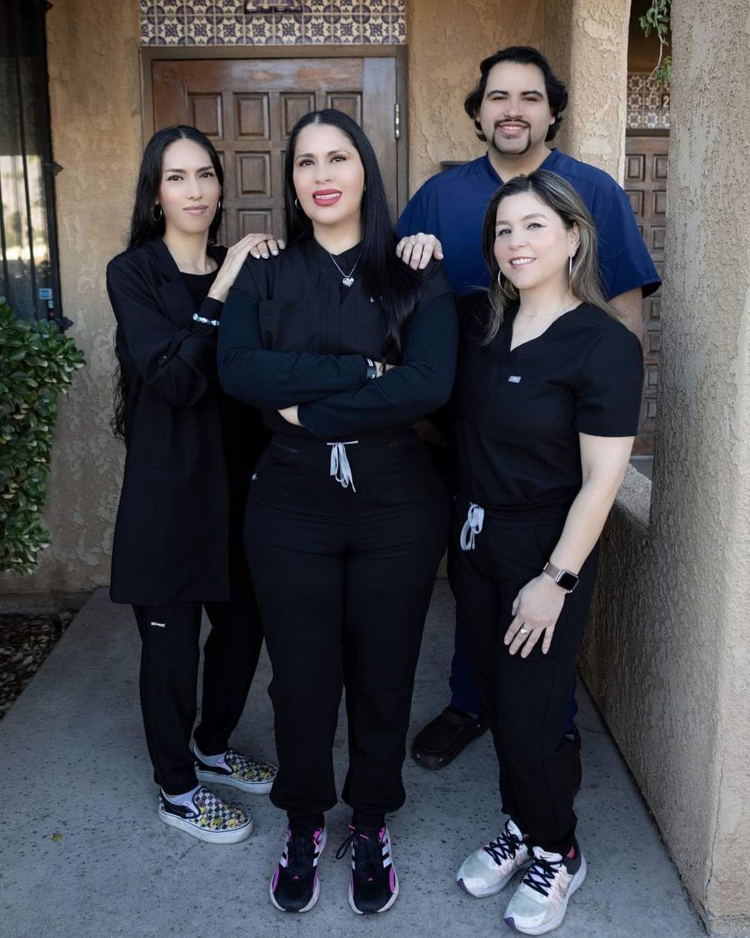 A group of people are posing for a picture in front of a building.