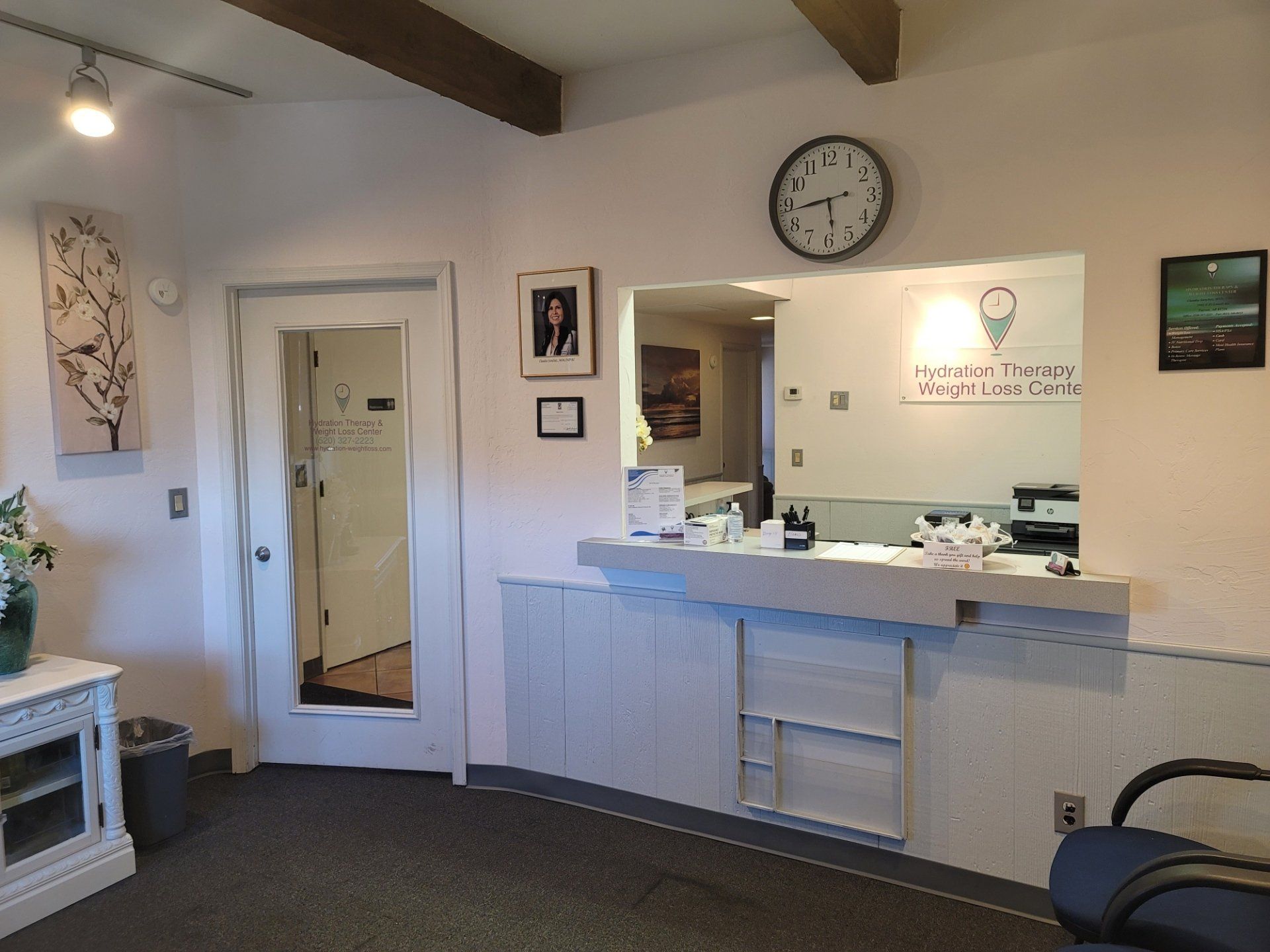 A waiting room with a counter and a clock on the wall.