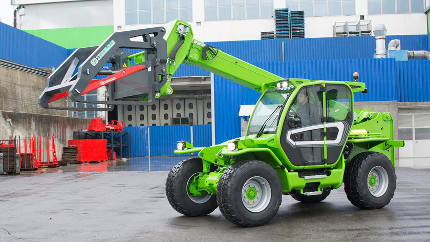 Chariot télescopique vert avec bras extensible et grappin pour usage extérieur.